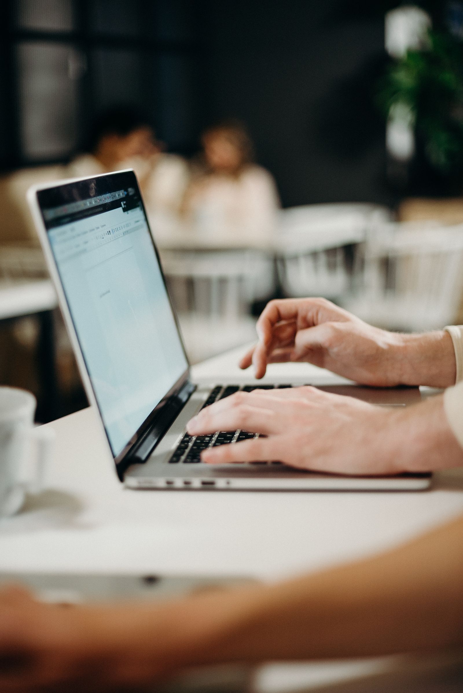 Writing an email campaign on a laptop in a café